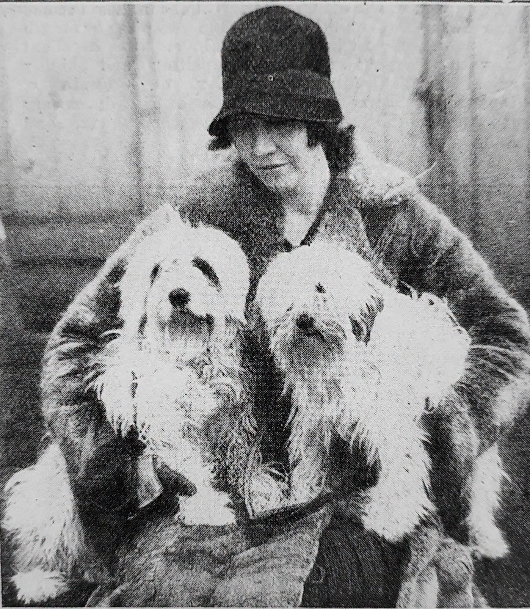 Dr. Agnes Greig in a 1920s cloche hat holding two Tibetan Terriers