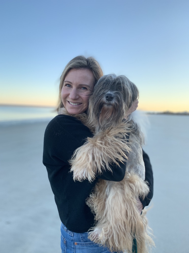 Deidre holding Cookie on the beach at sunset